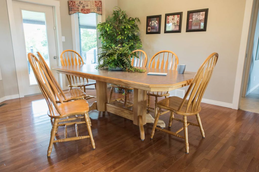 The dining room table is homemade, has a laminate surface, and has a pedestal base that is recessed far enough in that it does not pose an accessibility issue.