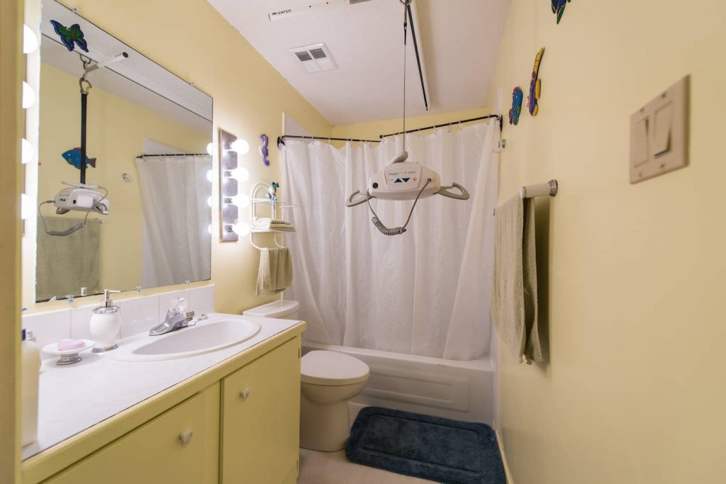 The homeowner uses a lift and the tub in the main bathroom for bathing, where either a tub bath is used, or a sling shower.
