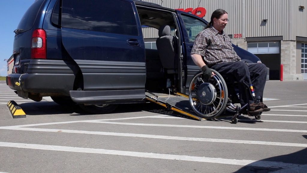 Man using wheelchair exiting minivan ramp